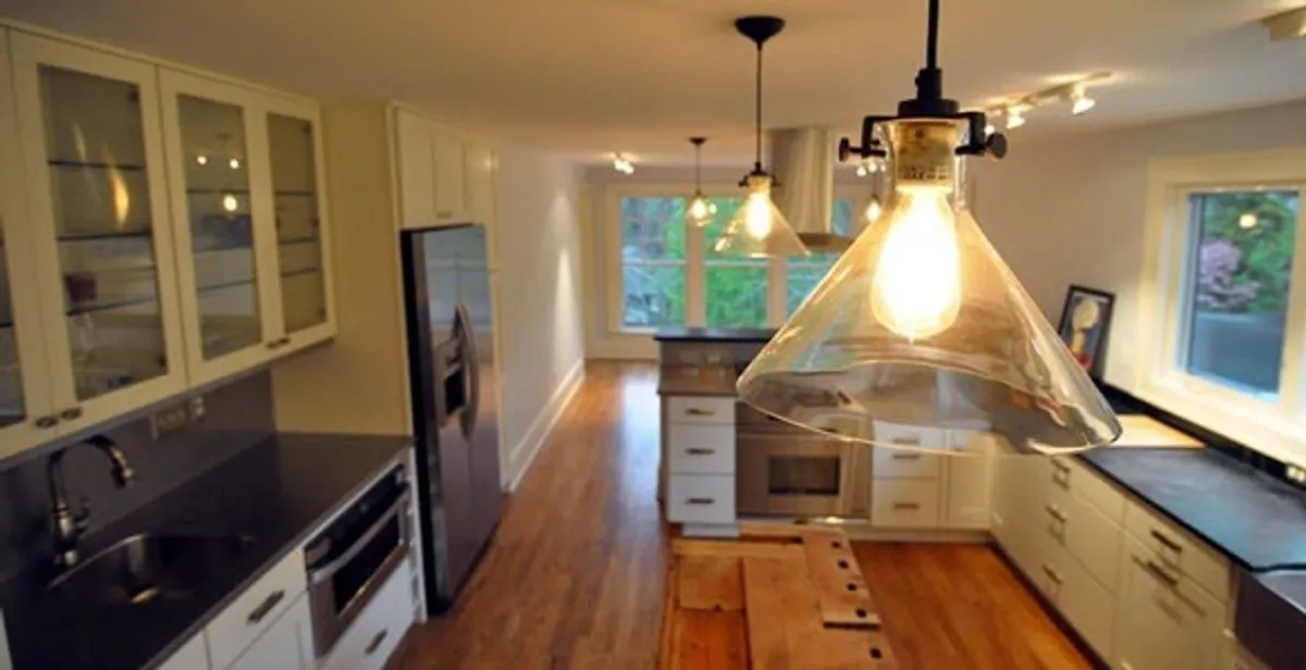 Residential electrician installing modern indoor light fixture in a home in Tucson, AZ